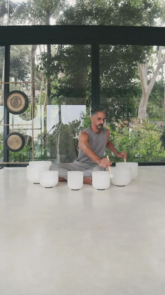 Sound healing instructor playing white crystal singing bowls inside a modern wellness studio in Sri Lanka