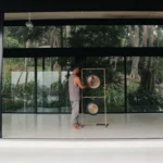 Therapist playing a sound healing gong during a restorative vibration session in Ahangama
