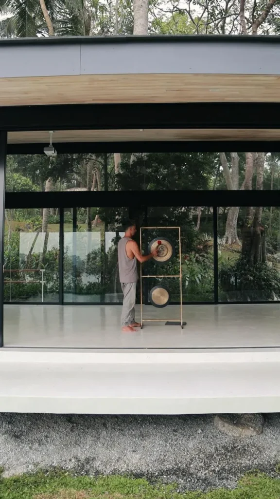 Therapist playing a sound healing gong during a restorative vibration session in Ahangama