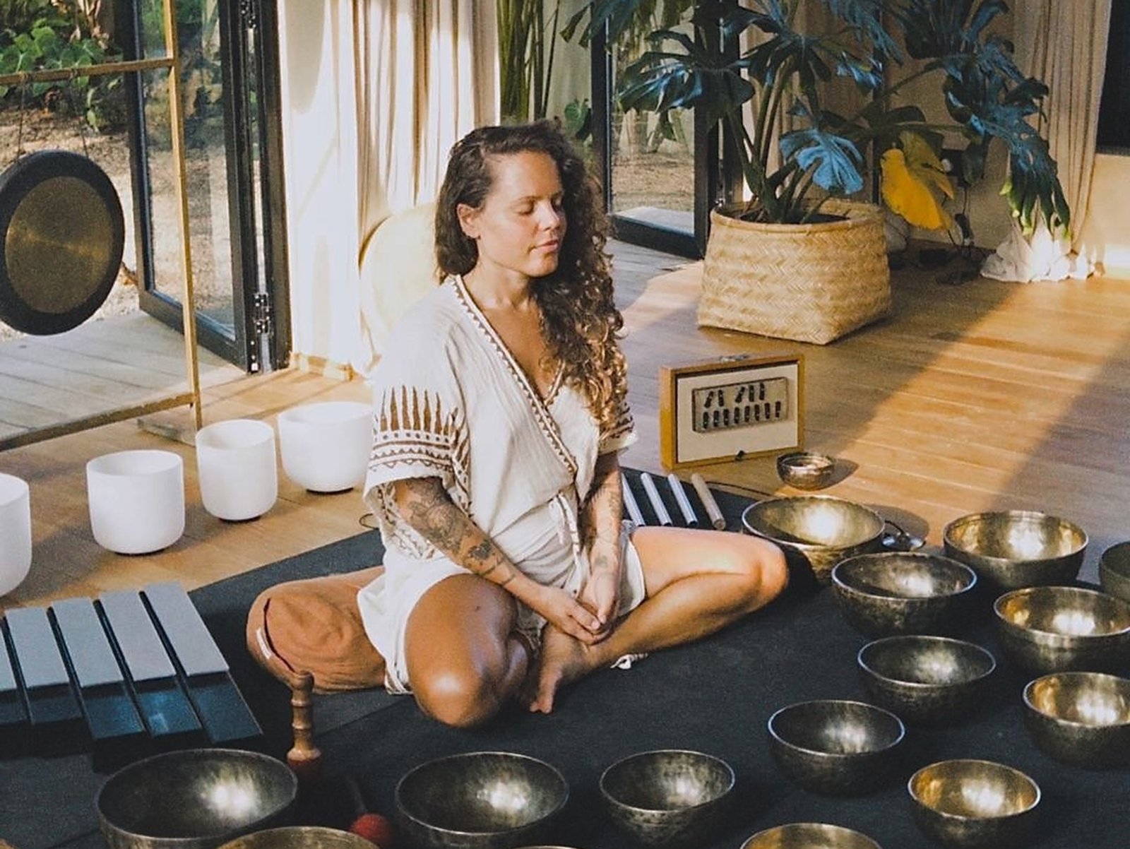 Female sound healing teacher guiding a meditative vibrational session with brass singing bowls in Ahangama