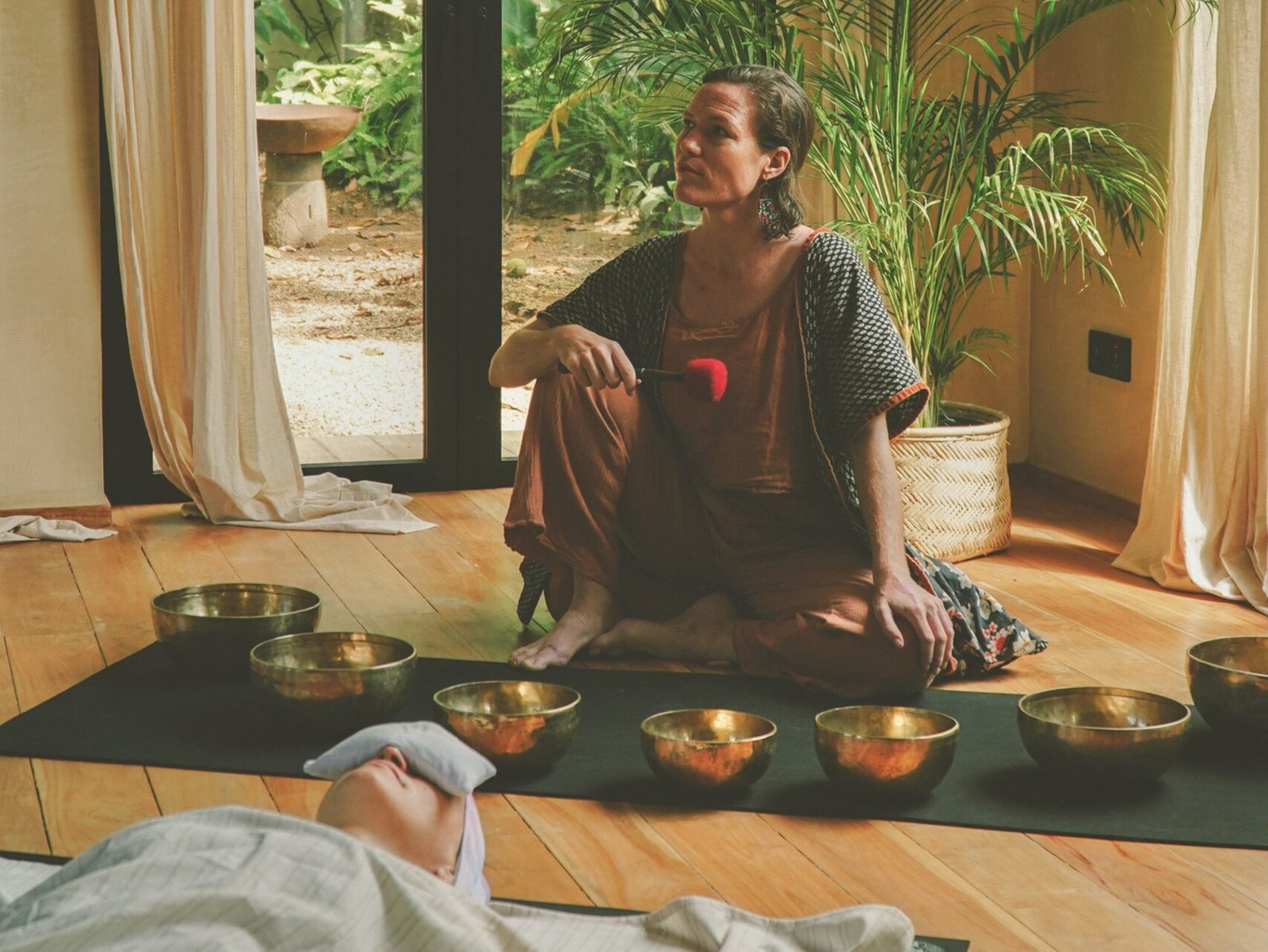 Sound healing practitioner guiding a private sound bath relaxation session with Tibetan brass bowls in Ahangama