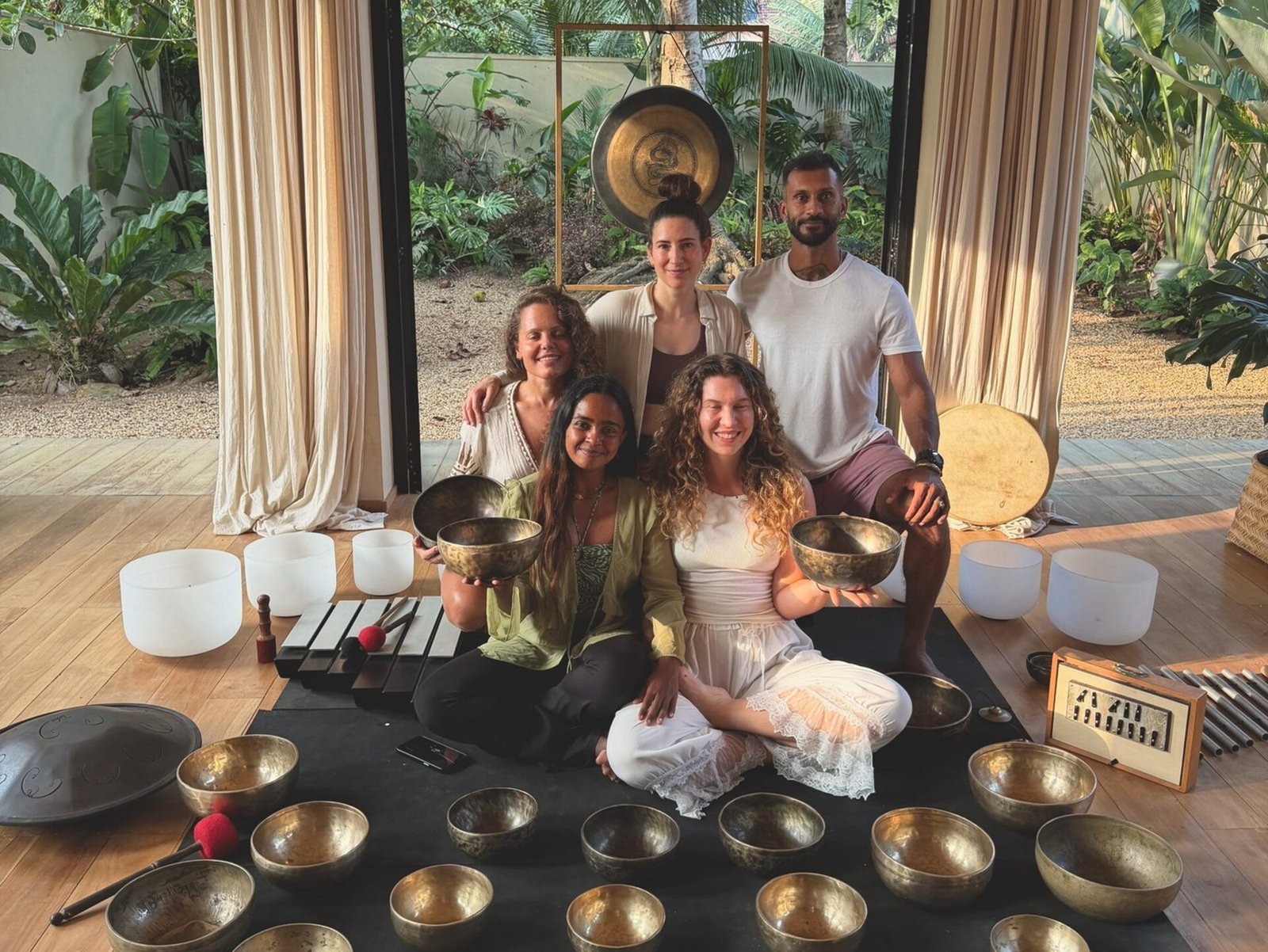 International students and wellness teachers holding singing bowls during a certified sound healing training course in Sri Lanka